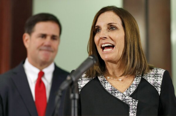 
              U.S. Rep. Martha McSally, R-Ariz., speaks, during a news conference Tuesday, Dec. 18, 2018, at the Capitol in Phoenix, after Arizona Gov. Doug Ducey, rear, announced his decision to replace U.S. Sen. Jon Kyl, R-Ariz. with McSally in the U.S. Senate seat that belonged to Sen. John McCain. McSally will take over after Kyl's resignation becomes effective Dec. 31. (AP Photo/Matt York)
            