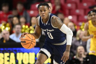 In this Dec. 22, 2022 file photo, Saint Peter's guard Latrell Reid in action during the first half of an NCAA college basketball game against Maryland in College Park, Md. Reid is the last player left from Saint Peter's incredible run to the Elite Eight two years ago. He was a seldom-used reserve then, but he's now the No. 2 scorer for a team that looks very different in its return to the NCAA Tournament after a wave of transfers following the 2022 run. (AP Photo/File, Nick Wass)