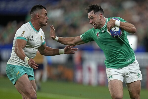Ireland's Hugo Keenan, right, holds off South Africa's Jesse Kriel during the Rugby World Cup Pool B match between South Africa and Ireland at the Stade de France in Saint-Denis, outside Paris, Saturday, Sept. 23, 2023. (AP Photo/Thibault Camus)