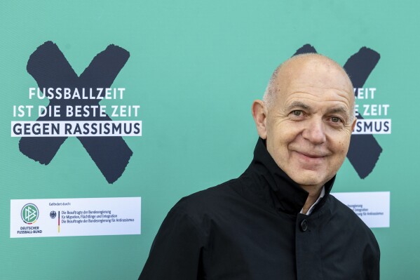 DFB President Bernd Neuendorf stands next to the campaign motto "Football time is the best time against racism" at the launch of the DFB's anti-racism campaign in Berlin, Germany, Monday March 18, 2024. (Soeren Stache/dpa via AP)