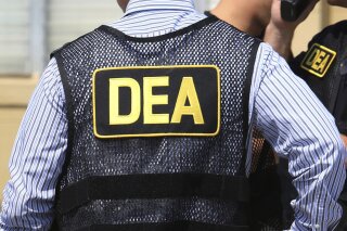 FILE - This June 13, 2016 file photo shows Drug Enforcement Administration (DEA) agents in Florida. On Friday, Feb. 21, 2020, the FBI arrested U.S. federal narcotics agent Jose Irizarry and his wife, Nathalia Gomez Irizarry, at their residence in Puerto Rico, according to a law enforcement official familiar with the arrest. He has been charged with conspiring to launder money with the very same Colombian drug cartels he was supposed to be fighting. (Joe Burbank/Orlando Sentinel via AP, File)