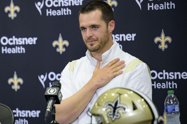 Derek Carr holds his chest in gratitude as he is introduced as the new quarterback of the New Orleans Saints during an NFL football press conference at the team's training facility in Metairie, La., Saturday, March 11, 2023. (AP Photo/Matthew Hinton)