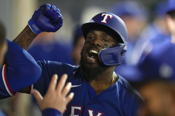 Texas Rangers' Adolis Garcia celebrates his home run with teammates in the dugout during the third inning of a baseball game against the Los Angeles Angels, Wednesday, Sept. 27, 2023, in Anaheim, Calif. (AP Photo/Jae C. Hong)