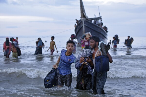 Ethnic Rohingya disembark from their boat upon landing in Ulee Madon, North Aceh, Indonesia, Thursday, Nov. 16, 2023. Some 240 Rohingya Muslims, including women and children, are afloat off the coast of Indonesia after two attempts to land were rejected by local residents. The boat left again a few hours later following the rejection. (AP Photo/Rahmat Mirza)