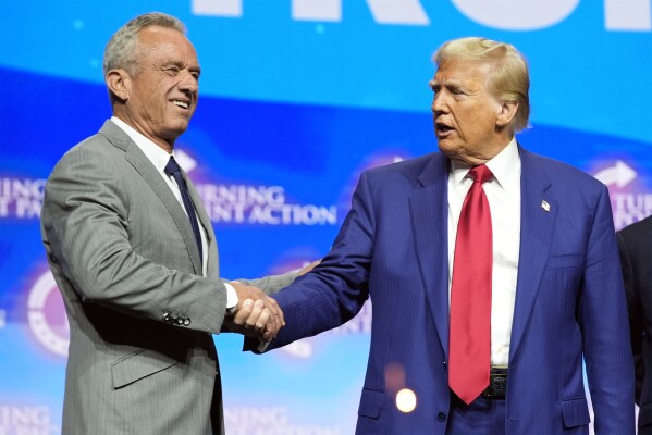 Republican presidential nominee former President Donald Trump shakes hands with Robert F. Kennedy Jr., at a Turning Point Action campaign rally, Wednesday, Oct. 23, 2024, in Duluth, Ga. (AP Photo/Alex Brandon)