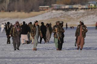 Taliban fighters walk at the frozen Qargha Lake, near Kabul, Afghanistan, in Kabul, Afghanistan, Friday, Feb. 11, 2022. The Taliban have detained two foreign journalists on assignment with the U.N. refugee agency and a number of its Afghan staff working in the country's capital, UNHCR said Friday. (AP Photo/Hussein Malla)
