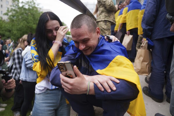 A Ukrainian soldier speaks by a phone to his relative after returning from captivity during a POWs exchange between Russia and Ukraine, in Chernyhiv region, Ukraine, Saturday, May 24, 2025. (AP Photo/Evgeniy Maloletka)