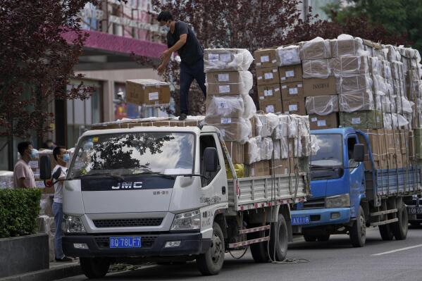 Workers load boxes of goods from a truck outside a wholesale clothing mall in Beijing on Tuesday, June 14, 2022. China's factory output rebounded in May, adding to a recovery from the latest COVID-induced economic slump after controls that shut down Shanghai and other industrial centers eased. (AP Photo/Andy Wong)