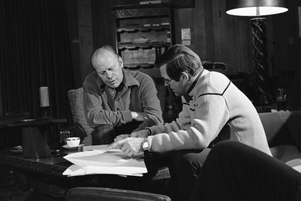 FILE - In this Dec. 24, 1974, file photo, President Gerald Ford and presidential assistant Donald Rumsfeld huddle over bills during work session in Vail, Colo. The president was spending a working holiday at the ski resort with his family. Rumsfeld, the two-time defense secretary and one-time presidential candidate, died Tuesday, June 29, 2021. He was 88. (AP Photo, File)