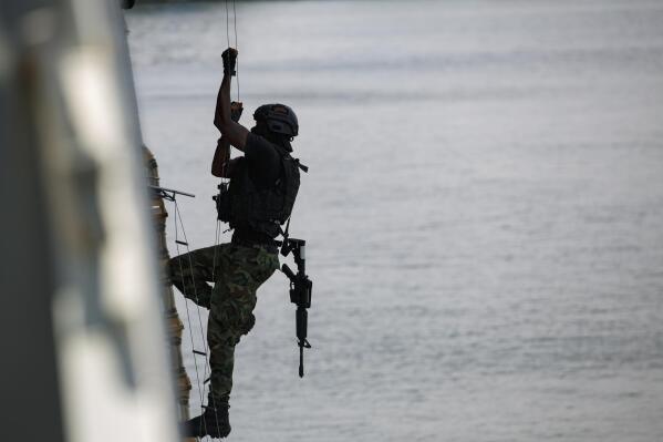 A Ghanaian soldier performs in hook and climb drills during Flintlock 2023 on a Spanish frigate at Tema port, Ghana, Thursday, March 9, 2023. Some 1,300 military personnel from 29 countries are training in Ghana and Ivory Coast, amid surging jihadi violence linked to al-Qaida and the Islamic State group that's killed thousands, displaced millions and plunged countries into crises. (AP Photo/Misper Apawu)
