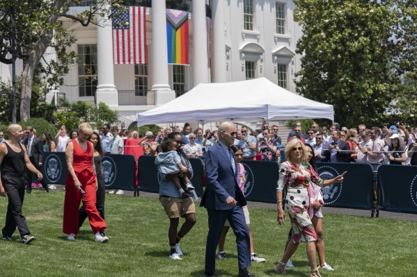 President Joe Biden, first lady Jill Biden and Betty Who, left in red, arrive for a Pride Month celebration on the South Lawn of the White House, Saturday, June 10, 2023, in Washington. (AP Photo/Manuel Balce Ceneta)