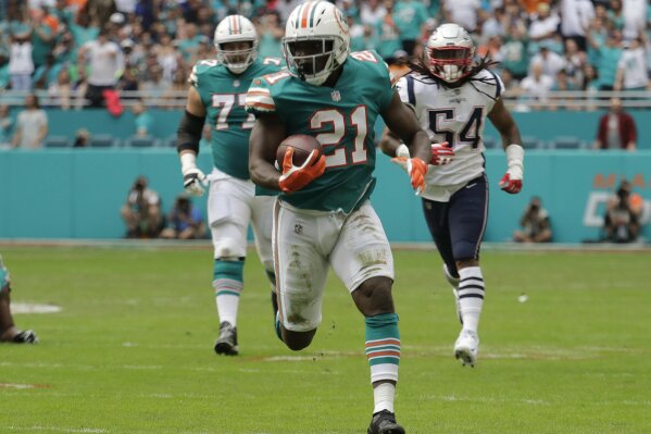 
              Miami Dolphins running back Frank Gore (21) runs the ball, during the first half of an NFL football game against the New England Patriots, Sunday, Dec. 9, 2018, in Miami Gardens, Fla. (AP Photo/Lynne Sladky)
            