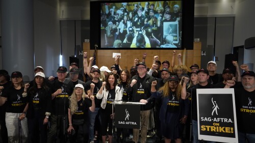 SAG-AFTRA president Fran Drescher and SAG-AFTRA National Executive Director and Chief Negotiator Duncan Crabtree-Ireland, center, pose with SAG-AFTRA members during a press conference announcing a strike by The Screen Actors Guild-American Federation of Television and Radio Artists on Thursday, July, 13, 2023, in Los Angeles. This marks the first time since 1960 that actors and writers will picket film and television productions at the same time. (AP Photo/Chris Pizzello)