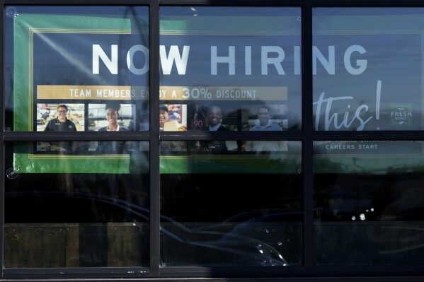 A hiring sign is displayed at a grocery store in Northbrook, Ill., Tuesday, Jan. 21, 2025. (AP Photo/Nam Y. Huh)