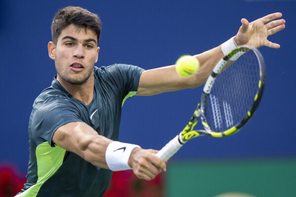 FILE - Carlos Alcaraz, of Spain, hits a return to Tommy Paul, of the United States, during the National Bank Open men's tennis tournament Friday, Aug. 11, 2023, in Toronto. Alcaraz is one of the men to watch at the U.S. Open, which begins at Flushing Meadows on Aug. 28.(Frank Gunn/The Canadian Press via AP, File)