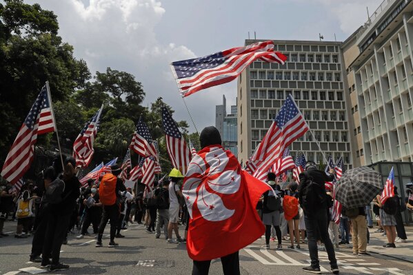 In this Sunday, Sept. 8, 2019 photo, protesters carry Hong Kong flag and U.S. flags during a demonstration near the U.S. Consulate in Hong Kong. China's decision to impose a national security law on Hong Kong is raising questions about the future of the semi-autonomous Chinese territory. The move bypasses Hong Kong's government _ which has not been able to enact such a law despite a requirement that it does _ and could allow the stationing of Chinese security officers in the city. A look at what it means and why people are concerned. (AP Photo/Kin Cheung)