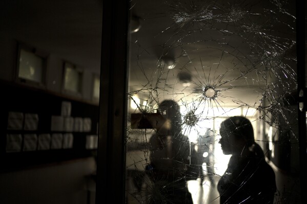 Bullet holes from the Oct. 7 cross-border attack by Hamas militants are seen in the door to the communal dining room in Kibbutz Nir Oz, near the Israel-Gaza border, on Nov. 21, 2023. An Associated Press review of hundreds of messages shared among Nir Oz residents, security camera footage and Hamas instruction manuals show the group planned ahead of time to target civilians, a change in tactic that heavily impacted how the war in Gaza played out. (AP Photo/Maya Alleruzzo)