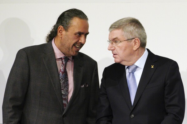 FILE - Sheikh Ahmad al Fahad al Sabah, left, president of the Association of National Olympic Committees (ANOC), and IOC President Thomas Bach talk prior to the opening of the ANOC general assembly in Tokyo, Wednesday, Nov. 28, 2018. Long-time Olympic power broker Sheikh Ahmad al-Fahad al-Sabah has been banished by the IOC for three years, it was announced Thursday, July 27, 2023. The International Olympic Committee says he influenced an Olympic Council of Asia election in Asia this month while self-suspended because of a forgery case in Geneva. (AP Photo/Eugene Hoshiko, fle)