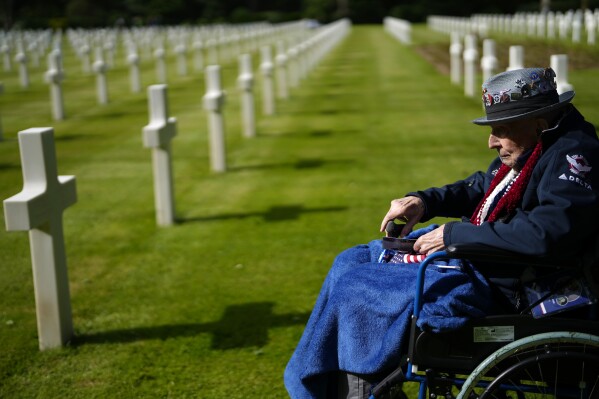 World War II and D-Day veteran Jake Larson visits the grave of a soldier from his unit at the Normandy American Cemetery in Colleville-sur-Mer, France, Tuesday, June 4, 2024. World War II veterans from across the United States as well as Britain and Canada are in Normandy this week to mark 80 years since the D-Day landings that helped lead to Hitler's defeat. (AP Photo/Virginia Mayo)