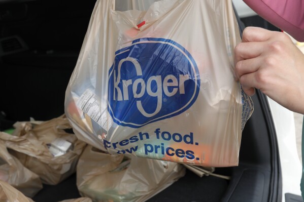 FILE - A customer removes her purchases at a Kroger grocery store in Flowood, Miss., Wednesday, June 26, 2019. Kroger and Albertsons are selling more than 400 stores and other assets to C&S Wholesale Grocers in an approximately $1.9 billion deal as part of their efforts to complete their merger, Friday, Sept. 8, 2023. (AP Photo/Rogelio V. Solis, File)