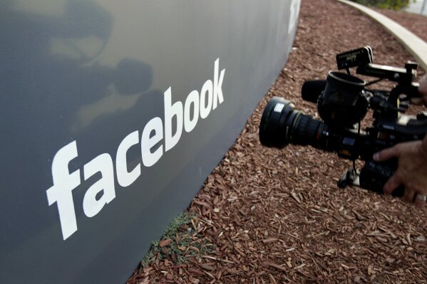 
              FILE- In this May 18, 2012, file photo a television photographer shoots the sign outside of Facebook headquarters in Menlo Park, Calif. Facebook has settled five lawsuits alleging that its advertising systems could be used to enable discrimination in housing, credit and employment ads, checking off one problem from its list of many. (AP Photo/Paul Sakuma, File)
            