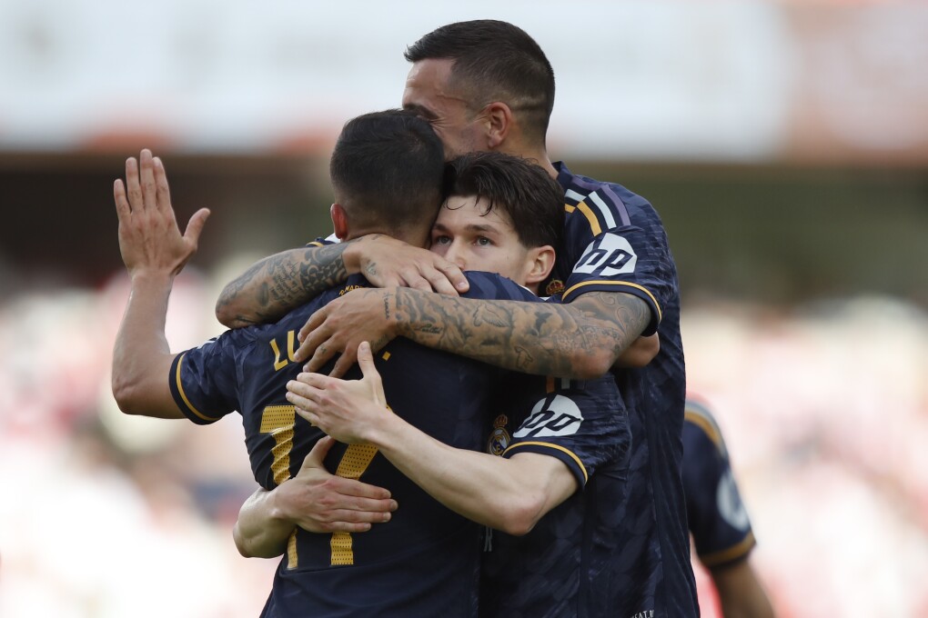 Real Madrid's Fran Garcia, center, is congratulated after scoring his side's opening goal during a Spanish La Liga soccer match between Granada FC and Real Madrid at Los Carmanes stadium in Granada, Spain, Saturday, May 11, 2024. (AP Photo/Fermin Rodriguez)