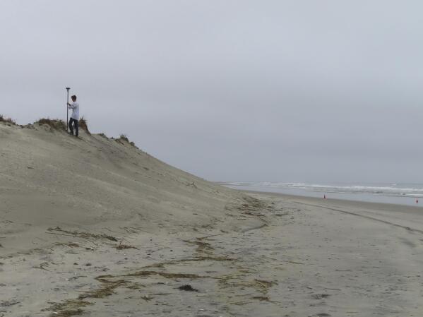 Survey work by a crew from Stockton University measures the countours of an eroded beach in North Wildwood, N.J. on Oct. 25, 2022. On Jan. 4, 2023, the city asked a judge to force the state environmental protection department to pay it $21 million to cover the cost of trucking in sand over the past decade. (AP Photo/Wayne Parry)