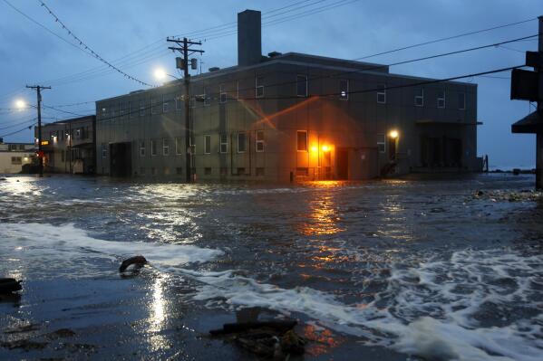 Water rushes down Front Street, just a half block from the Bering Sea, in Nome, Alaska, on Saturday, Sept. 17, 2022 as the remnants of Typhoon Merbok moved into the region. It was a massive storm system — big enough to cover the mainland U.S. from the Pacific Ocean to Nebraska and from Canada to Texas. It influenced weather systems as far away as California, where a rare late-summer storm dropped rain on the northern part of the state, offering a measure of relief to wildfire crews but also complicating fire suppression efforts because of mud and loosened earth. (AP Photo/Peggy Fagerstrom)