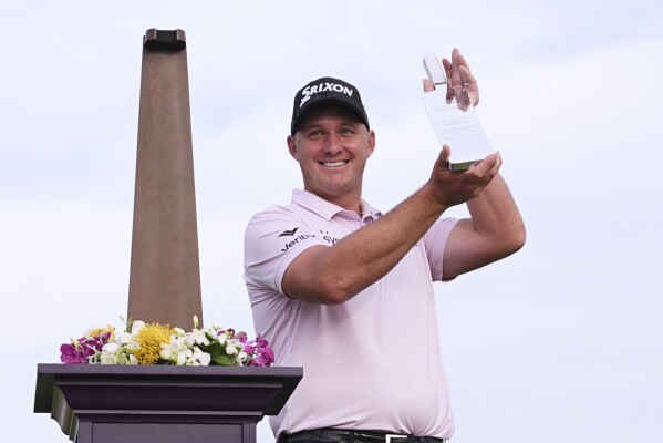 Sepp Straka, of Austria, poses with the trophy after winning the Truist Championship golf tournament at the Philadelphia Cricket Club, Sunday, May 11, 2025, in Flourtown. (AP Photo/Matt Rourke)