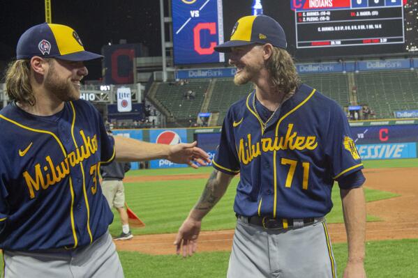 Milwaukee Brewers starter Corbin Burnes, left, and reliever Josh Hader celebrate after pitching a combined no-hitter against the Cleveland Indians in a baseball game in Cleveland, Saturday, Sept. 11, 2021. (AP Photo/Phil Long)