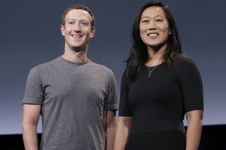 FILE- In this Sept. 20, 2016, file photo, Facebook CEO Mark Zuckerberg and his wife, Priscilla Chan, smile as they prepare for a speech in San Francisco. Facebook founder Mark Zuckerberg and his wife, Priscilla Chan, on Tuesday, Oct. 13, 2020, donated an additional $100 million to helping local election offices prepare for November even as some conservatives are stepping up their efforts to stop the funds from being used. (AP Photo/Jeff Chiu, File)