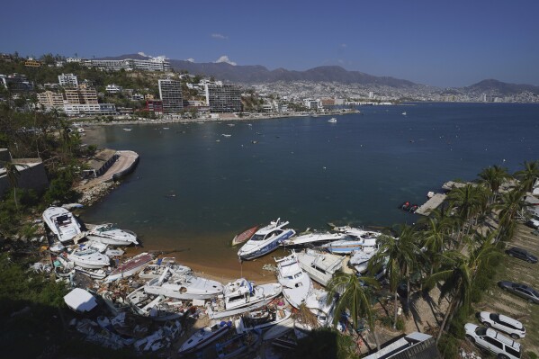 Docked yachts damaged by Hurricane Otis are seen, in Acapulco, Mexico, Sunday, Nov. 12, 2023. Nearly three weeks after the Category 5 hurricane devastated this Pacific port, leaving at least 48 people dead and the city's infrastructure in tatters, the cleanup continues. (AP Photo/Marco Ugarte)