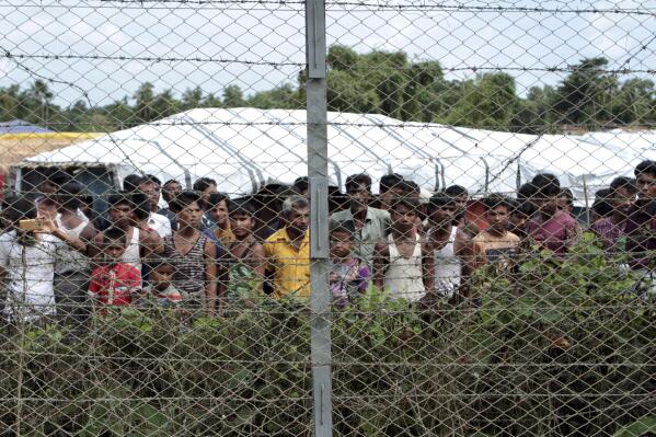 FILE - Rohingya refugees gather near a fence during a government organized media tour, to a no-man's land between Myanmar and Bangladesh, near Taungpyolatyar village, Maung Daw, northern Rakhine State, Myanmar, June 29, 2018. An international case accusing Myanmar of genocide against the Rohingya ethnic minority returns to the United Nations' highest court Monday, Feb. 21, 2022, amid questions over whether the country's military rulers should even be allowed to represent the Southeast Asian nation. (AP Photo/Min Kyi Thein, File)