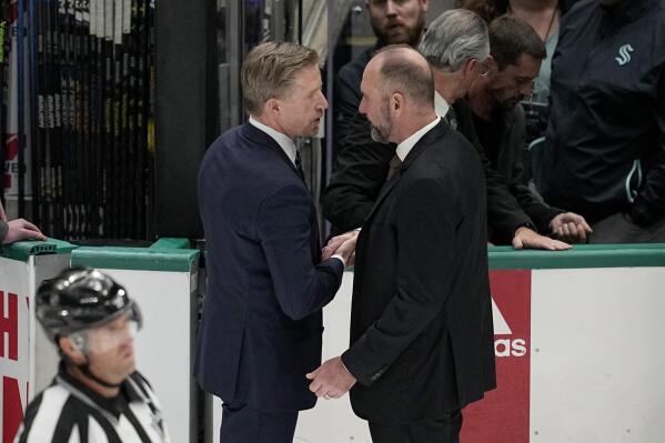 Seattle Kraken head coach Dave Hakstol, left, and Dallas Stars head coach Peter DeBoer, right, shake hands after Game 7 of an NHL hockey Stanley Cup second-round playoff series, Monday, May 15, 2023, in Dallas. (AP Photo/Tony Gutierrez)