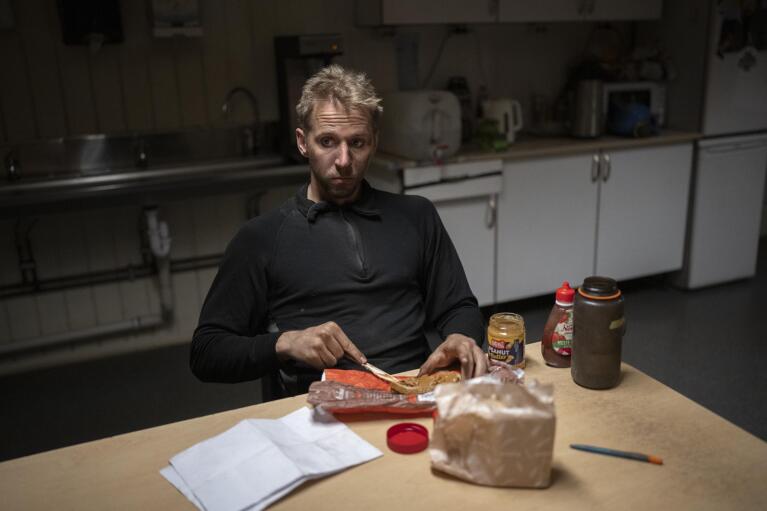 A coal miner makes a sandwich in the break room of the Gruve 7 coal mine in Adventdalen, Norway, Monday, Jan. 9, 2023. The mine is scheduled to be shut down in two years, cutting carbon dioxide emissions in this fragile, rapidly changing environment, but also erasing the identity of a century-old mining community that fills many with deep pride even as the primary activities shift to science and tourism. (AP Photo/Daniel Cole)