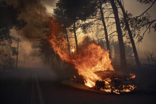 A wildfire close to Greece’s capital darkens the skies over Athens and advances speedy