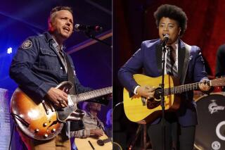 Jason Isbell performs at the To Nashville, With Love Benefit Concert in Nashville, Tenn. on March 9, 2020, left, and Amythyst Kiah of Our Native Daughters performs during the Americana Honors & Awards show in Nashville, Tenn. on Sept. 11, 2019. Singer-songwriters Isbell and  Kiah are both up for three nominations at this year's Americana Honors and Awards Show. This year's show will resume in-person on September 22 after the ceremony was cancelled last year due to the pandemic. (AP Photo)