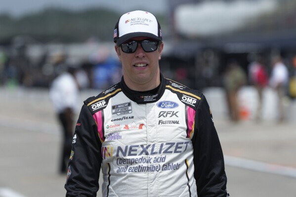 Brad Keselowski walks to his car during qualifications for a NASCAR Cup Series auto race at Michigan International Speedway in Brooklyn, Mich., Saturday, Aug. 5, 2023. (AP Photo/Paul Sancya)