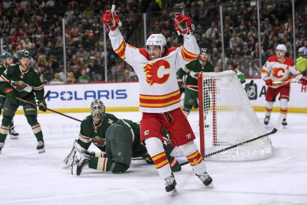 FILE - Calgary Flames left wing Johnny Gaudreau celebrates his goal on Minnesota Wild goalie Cam Talbot during the second period of an NHL hockey game Thursday, April 28, 2022, in St. Paul, Minn. The Columbus Blue Jackets made the biggest splash, stunning the league by landing Johnny Gaudreau with a seven-year contract for $68.25 million, Wednesday, July 13, 2022.(AP Photo/Craig Lassig, File)