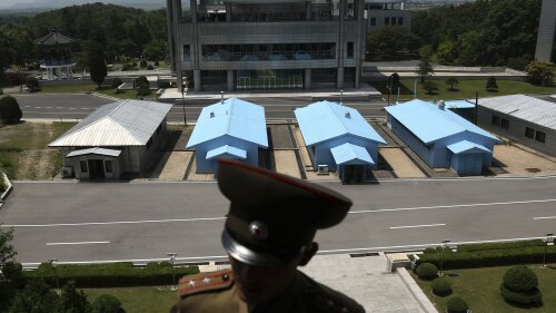                A South Korean building complex is seen in the background as North Korean soldiers guard the truce village at the Demilitarized Zone (DMZ) which separates the two Koreas in Panmunjom, North Korea, Wednesday, June 20, 2018. A tour guide Hwang Myong Jin, on the northern side of the Demilitarized Zone that divides the two Koreas, says that since the summits between North Korean leader Kim Jong Un and the presidents of South Korea and the United States, things have quieted down noticeably in perhaps the most iconic symbol of the one last place on Earth where the Cold War still burns hot. (AP Photo/Dita Alangkara)             