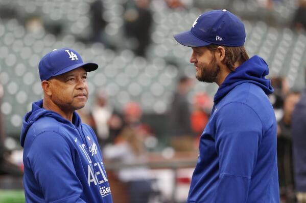 Los Angeles Dodgers manager Dave Roberts, left, talks with injured pitcher Clayton Kershaw before Game 1 of a baseball National League Division Series against the San Francisco Giants Friday, Oct. 8, 2021, in San Francisco. (AP Photo/Jed Jacobsohn)