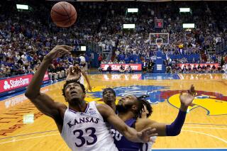 Kansas forward David McCormack (33) shoots under pressure from TCU center Eddie Lampkin (4) during the first half of an NCAA college basketball game Thursday, March 3, 2022, in Lawrence, Kan. (AP Photo/Charlie Riedel)