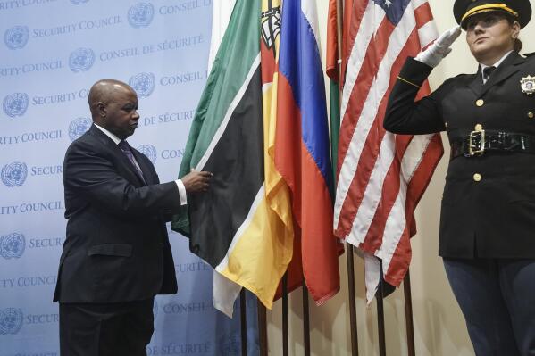CORRECTS NAME TO PEDRO COMISSARIO - Mozambique's United Nations Ambassador Pedro Comissário Afonso, left, installs his country's flag during ceremony for five newly-elected non-permanent members to serve on the United Nations Security Council for the term 2023-2024, Tuesday Jan. 3, 2023 at U.N. headquarters. (AP Photo/Bebeto Matthews)