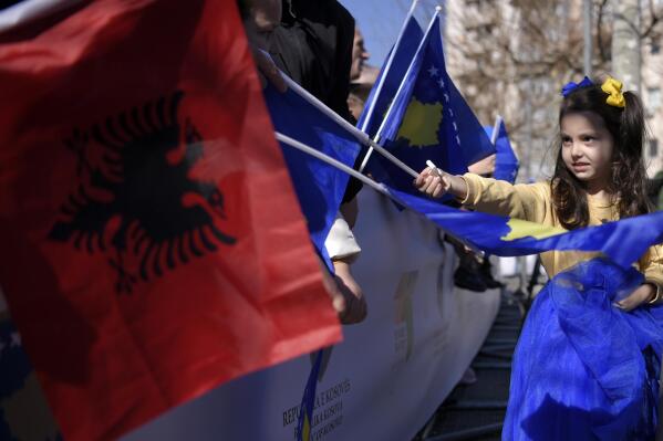 People wave Albanian and national flags during celebrations to mark the 15th anniversary of independence, in Pristina, Kosovo, Friday, Feb. 17, 2023. Europe's youngest country, Kosovo, on Friday launched festivities for the 15th anniversary of its independence from neighboring Serbia with a military parade, wreath-laying ceremonies and a special Parliament session. But the celebrations are overcast by revived tension with Serbia, despite yearslong Western efforts to reconcile the former foes. (AP Photo)