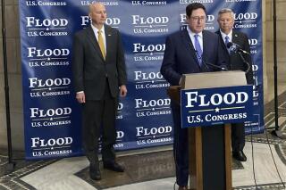 Nebraska state Sen. Mike Flood, center, announces the endorsements of Gov. Pete Ricketts, left and former Gov. Dave Heineman, right in his campaign to unseat fellow Republican U.S. Rep. Jeff Fortenberry, during a news conference on Friday, Jan. 21, 2022 , at the Nebraska Capitol in Lincoln, Neb. . (Martha Stoddard/Omaha World-Herald via AP)