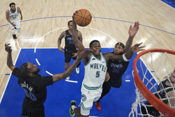 Minnesota Timberwolves guard Anthony Edwards (5) goes up for a shot as Dallas Mavericks forward Derrick Jones Jr. (55) and center Daniel Gafford (21) defend during the second half of Game 2 of the NBA basketball Western Conference finals Friday, May 24, 2024, in Minneapolis. (AP Photo/Abbie Parr)