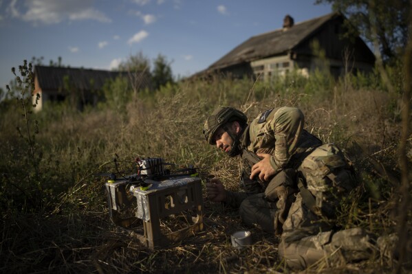 A Ukrainian soldier nicknamed Stem checks a loaded exploding drone before takeoff on the front line in the outskirts of Kremmina, Ukraine, Sunday, Aug. 20, 2023. (AP Photo/Bram Janssen)
