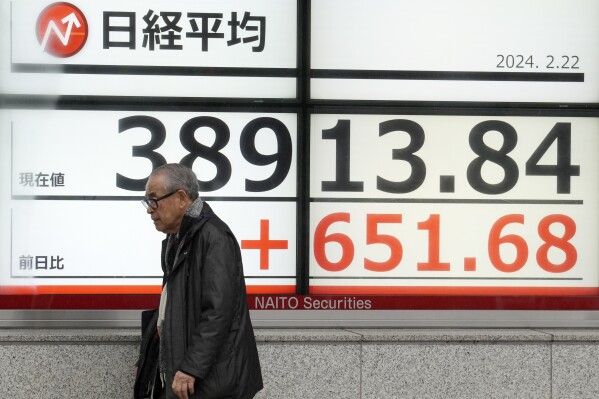 A person walks in front of an electronic stock board showing Japan's Nikkei 225 index at a securities firm Thursday, Feb. 22, 2024, in Tokyo. Japan鈥檚 Nikkei 225 share index surged briefly to an all-time high on Thursday, bypassing its previous record set in December 1989.(APPhoto/Eugene Hoshiko)