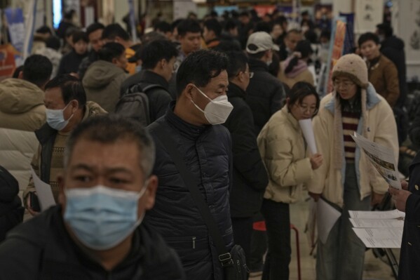 Job seekers crowded at a job fair as they look for vacancies in Beijing on Feb. 23, 2024. China's efforts to restore confidence and rev up the economy will top the agenda during this month’s meeting of the ceremonial national legislature. (AP Photo/Andy Wong)