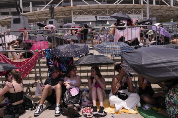 Taylor Swift fans wait for the doors of Nilton Santos Olympic stadium to open for her Eras Tour concert amid a heat wave in Rio de Janeiro, Brazil, Saturday, Nov. 18, 2024. A 23-year-old Taylor Swift fan died at the singer's Eras Tour concert in Rio de Janeiro Friday night, according to a statement from the show's organizers in Brazil. (澳洲幸运5开奖官网结果直播开奖 AP Photo/Silvia Izquierdo)